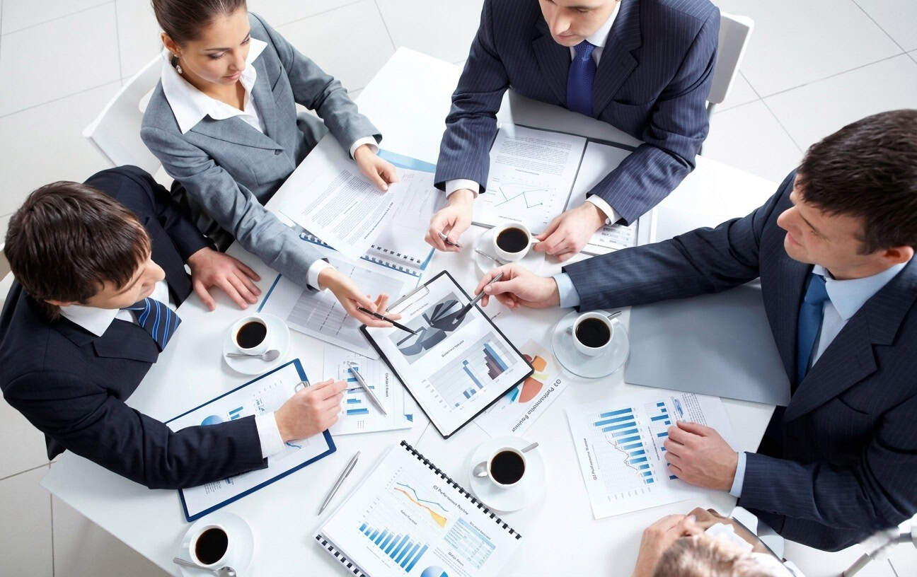 Business team discussing strategies with charts and tablets in a modern office.